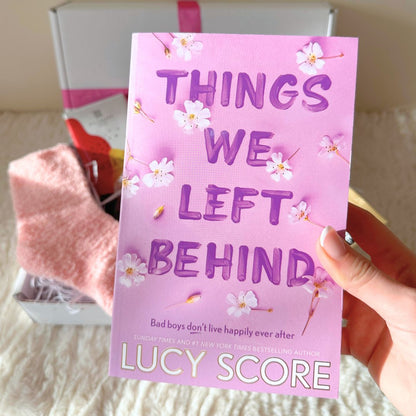 Paperback copy of The Things We Left Behind book by Lucy Score which is included in the Ladies &